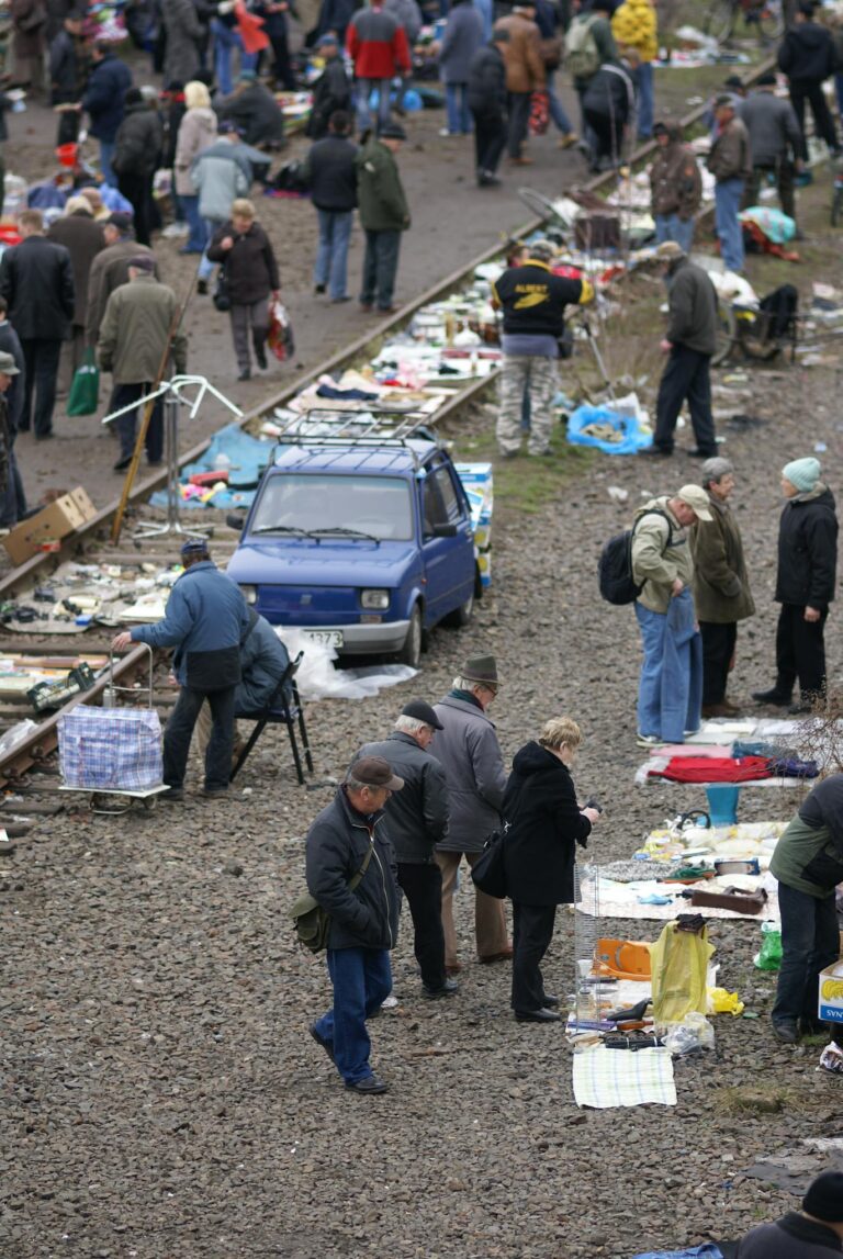 A lively outdoor flea market in Wrocław with people browsing stalls and goods.