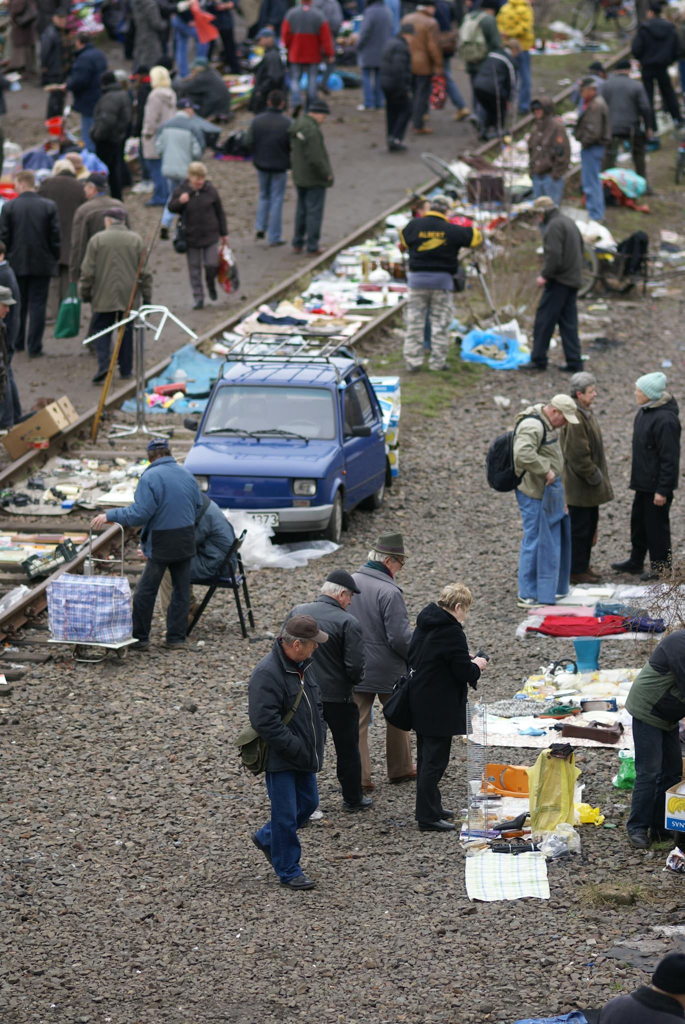 A lively outdoor flea market in Wrocław with people browsing stalls and goods.